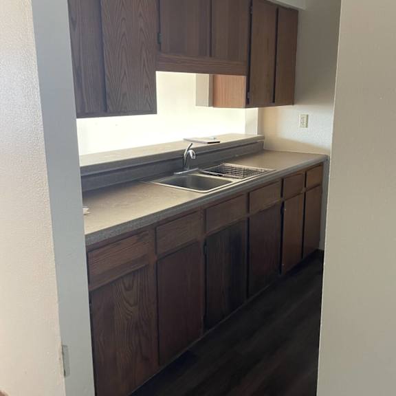 a kitchen with wooden cabinets and a stainless steel sink.