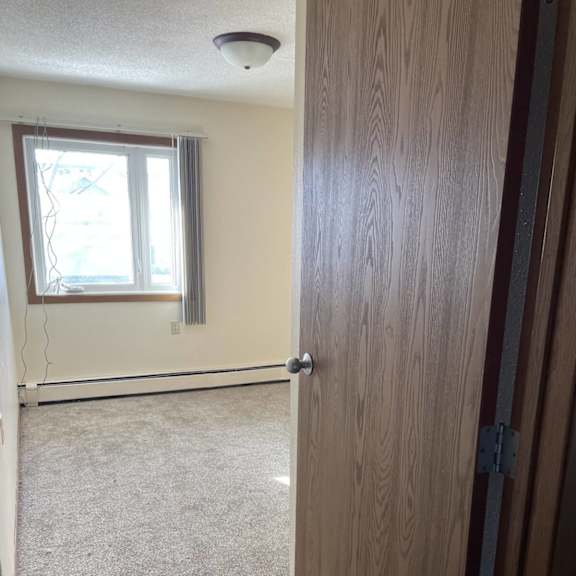 a room with a carpeted floor and a closed door.