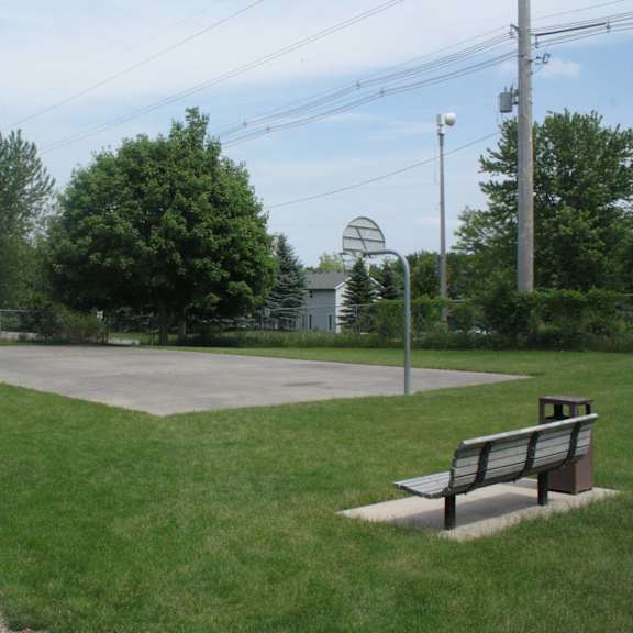 a basketball court with a bench and a fence.