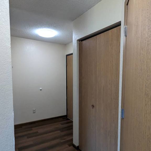 a hallway with a wooden door on the right.