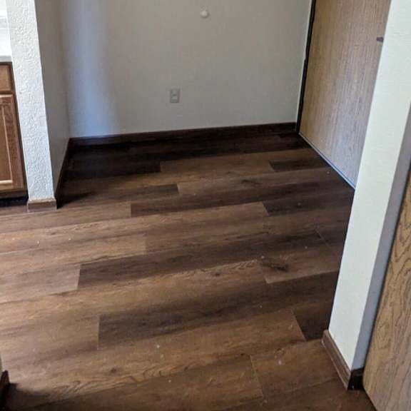 a room with wooden floors and a door on the right.