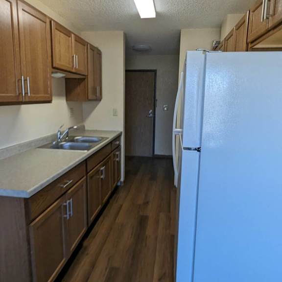 a kitchen with wooden cabinets and a white refrigerator.