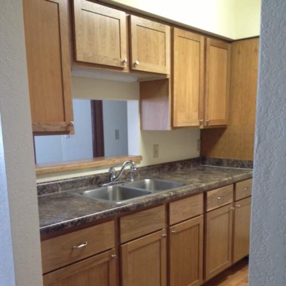 a kitchen with wooden cabinets and a granite countertop.