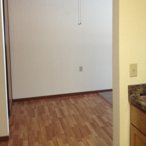 a room with a ceiling fan and wooden flooring.