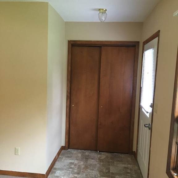a room with a brown door and a tiled floor.