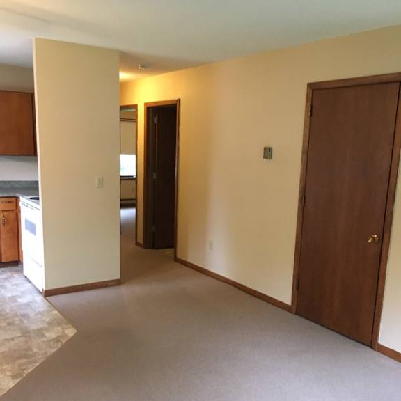a room with a carpeted floor and two doors.