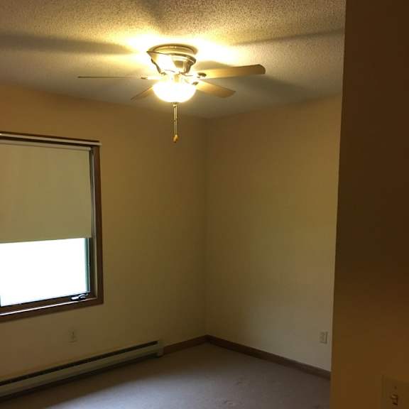 a room with a window and a ceiling fan.