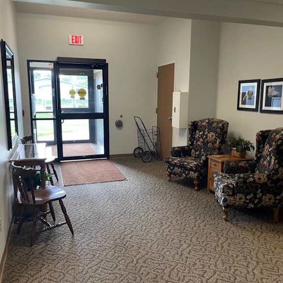 a hallway with a chair, a table, and a bicycle.