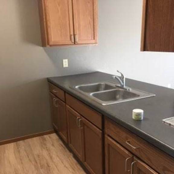 a kitchen with wooden cabinets and a grey countertop.