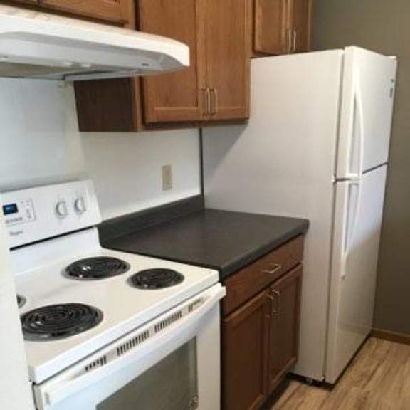 a white stove and oven in a kitchen with wooden cabinets.