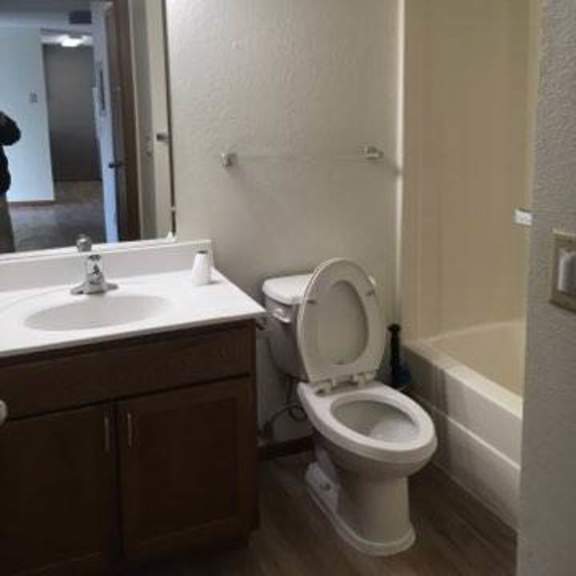 a white toilet is in a bathroom with a sink and mirror.