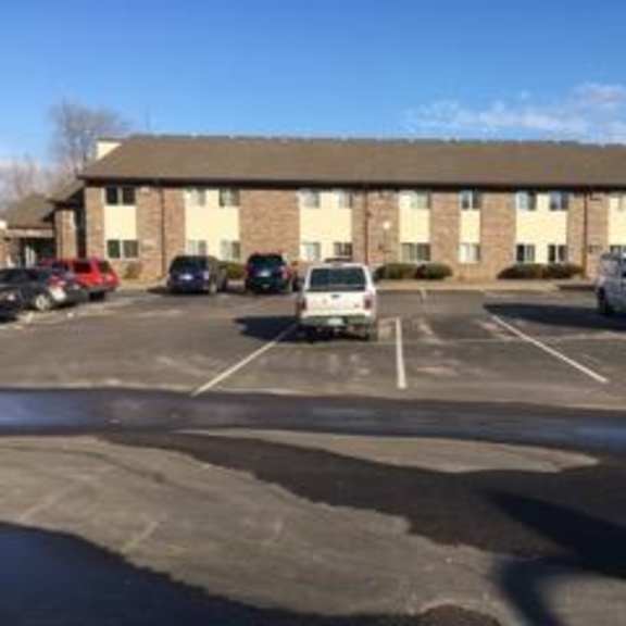 a parking lot with cars and a building in the background.