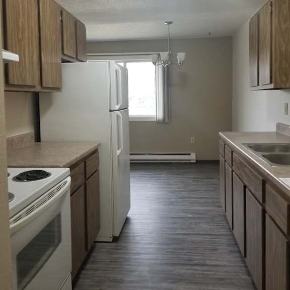 a kitchen with wooden cabinets and a white refrigerator.