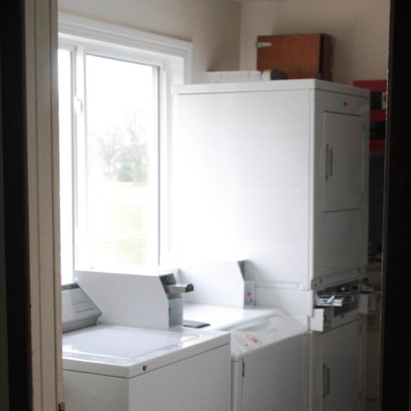 a white washing machine and dryer in a small laundry room.