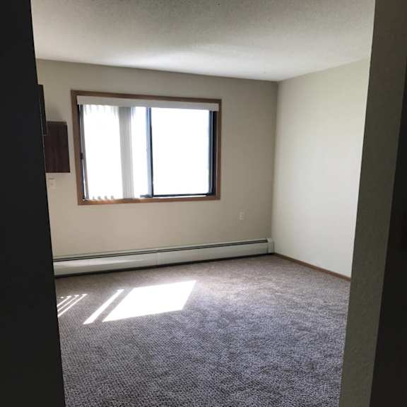 a room with a window and carpeted floor.