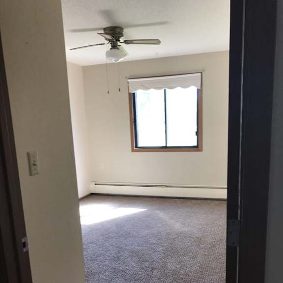 a room with a ceiling fan and a window.
