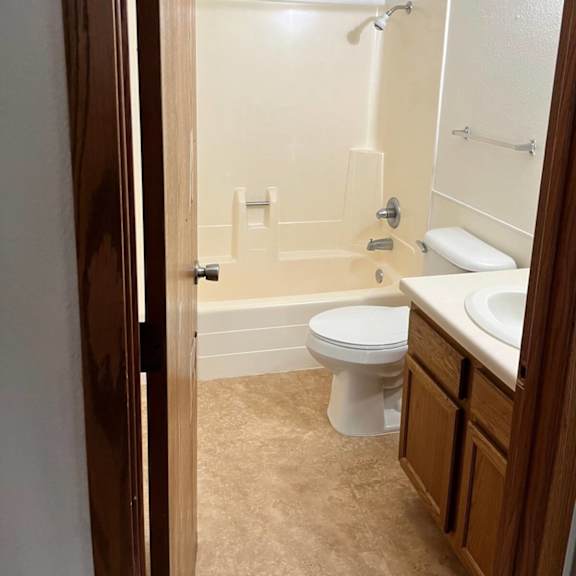 a bathroom with a toilet, sink, and bathtub.