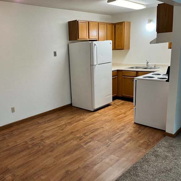 a kitchen with a white refrigerator and wooden cabinets.