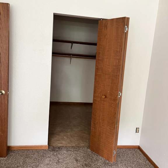a room with a brown door and a carpeted floor.