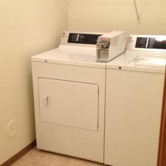 a white washer and dryer in a small bathroom.