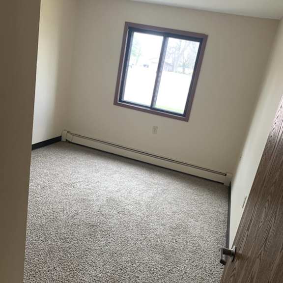 a room with a carpeted floor and a window.