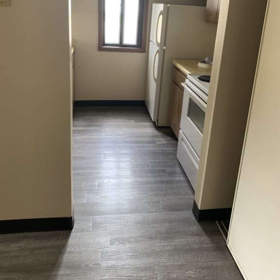 a kitchen with a refrigerator, oven, and sink.