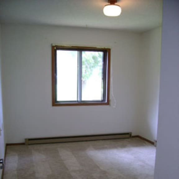 a room with a carpeted floor and a window.