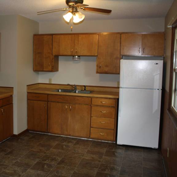 a kitchen with wooden cabinets and a white refrigerator.