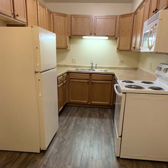a kitchen with a white refrigerator and a white stove.