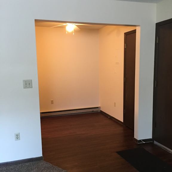 a room with a wooden floor and a brown door.