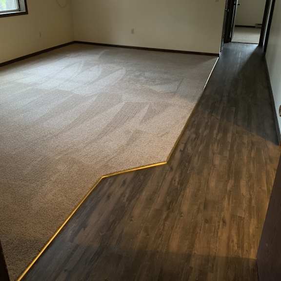 a room with a carpeted floor and a wooden floor.