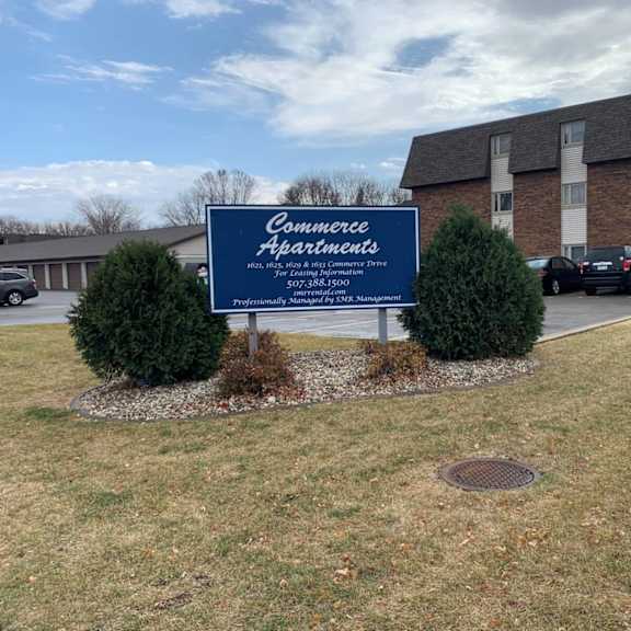 a sign for commerce apartments is in front of a brick building.