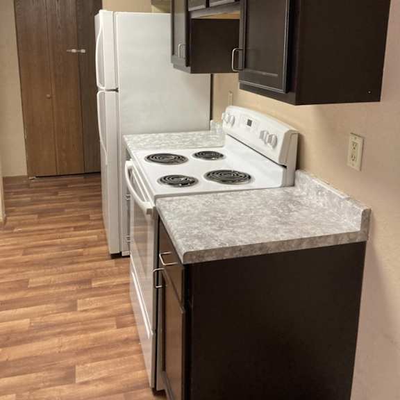 a kitchen with a white stove top oven and a white refrigerator.