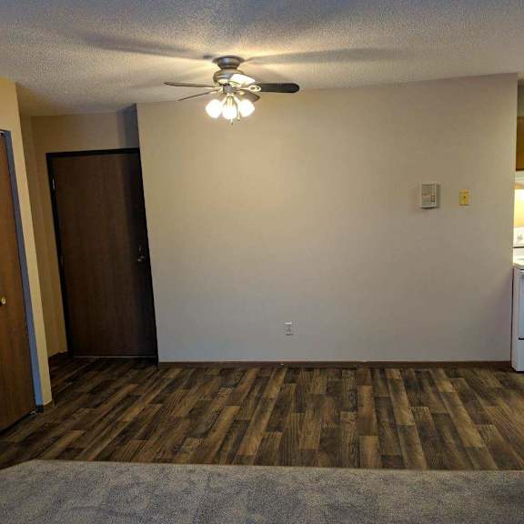 a room with a ceiling fan and a wooden floor.