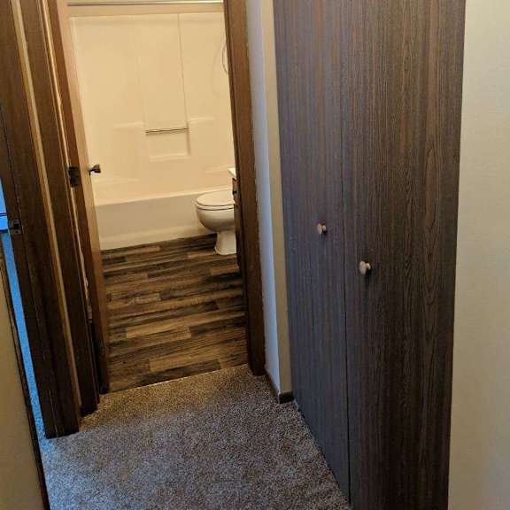 a bathroom with a toilet and a wooden door.