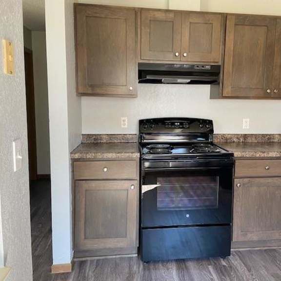a black stove top oven in a kitchen with wooden cabinets.