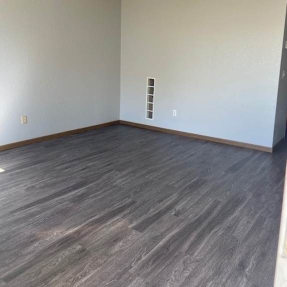 a room with a grey floor and a white wall with a small shelf.