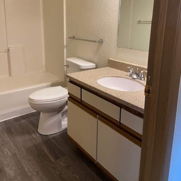 a bathroom with a toilet, sink and mirror.