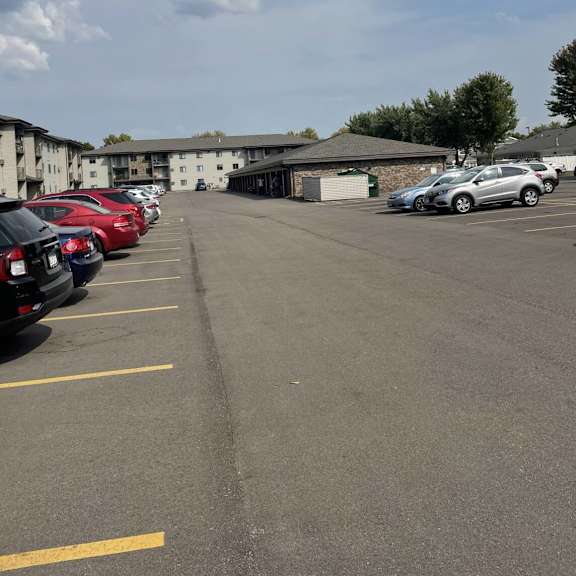 a parking lot with cars and a building in the background.