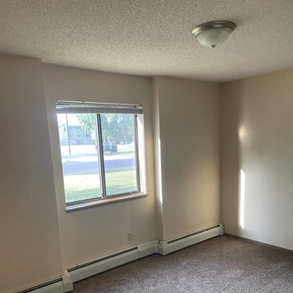 a room with a carpeted floor and a window.