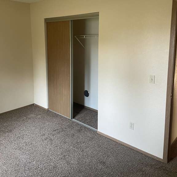 a room with a brown door and carpeted floor.