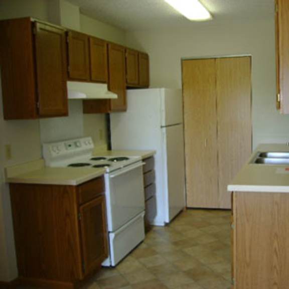 a kitchen with wooden cabinets and a white stove.