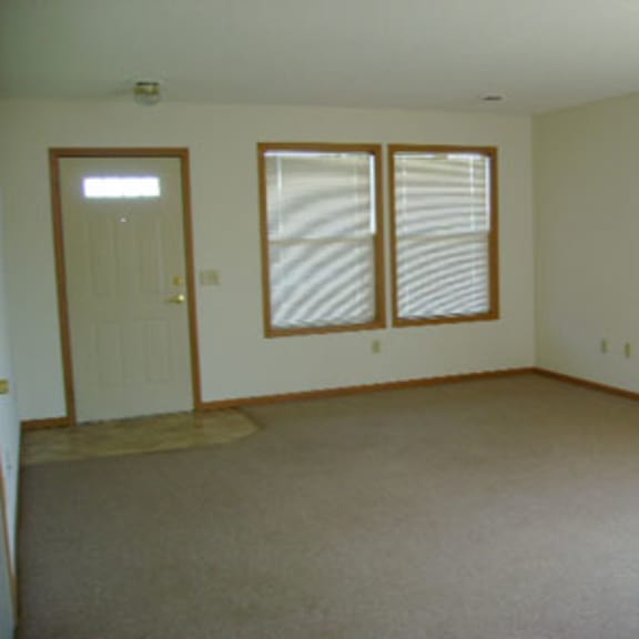 a room with a carpeted floor and a door.