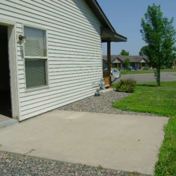 a house with a white siding and a window with a screen door open.