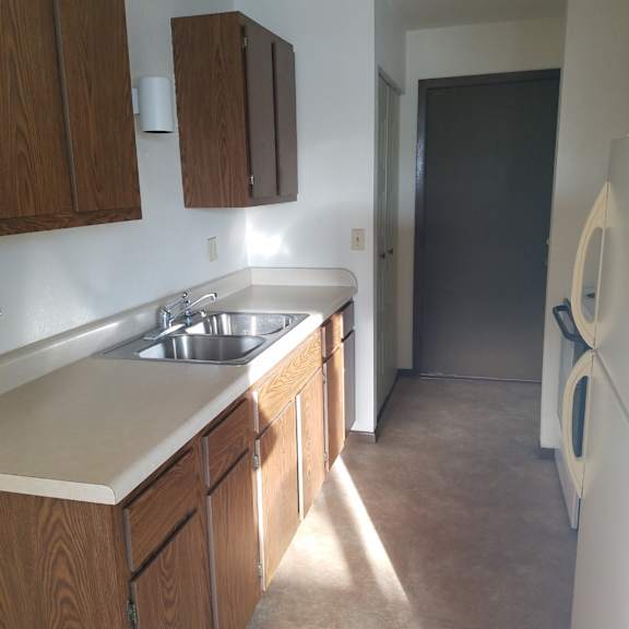 a kitchen with wooden cabinets and a white sink.