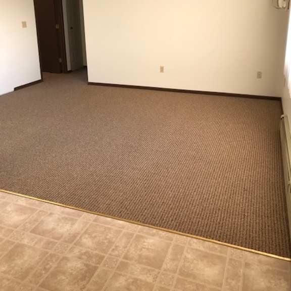 a room with a carpeted floor and a door.