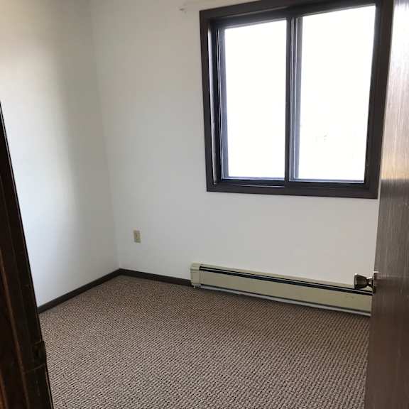 a room with a carpeted floor and a window.