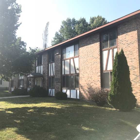 a house with a brown brick exterior and a white window.