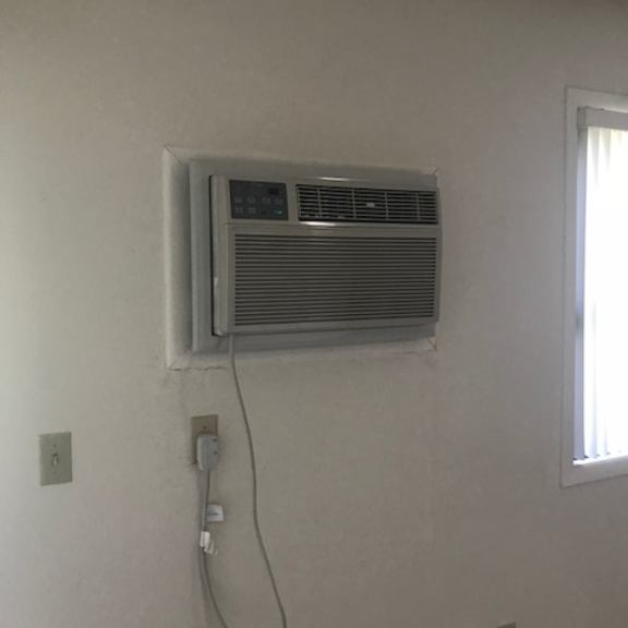 a wall-mounted air conditioner unit is plugged into an outlet.