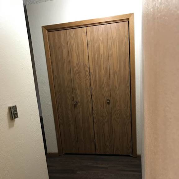 a wooden door is closed in a room with a grey floor.